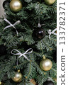 Christmas tree decorated with white bows and black and gold ornaments 133782371