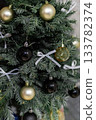 Christmas tree decorated for the holiday with white bows and festive ornaments 133782374