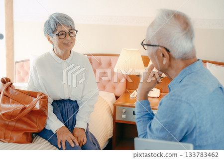 一對老年夫婦在飯店房間裡愉快地交談 133783462