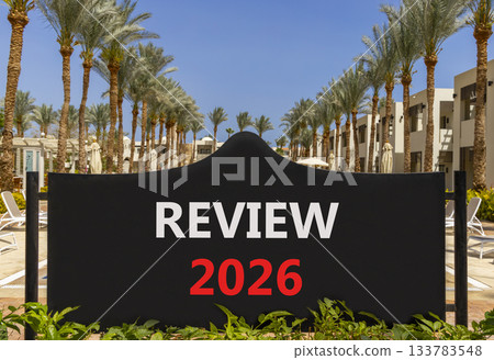 Review 2026 symbol. Concept words Review 2026 on beautiful black road sign. Beautiful palm trees palm-trees and blue sky background. Business and review 2026 concept. Copy space. 133783548