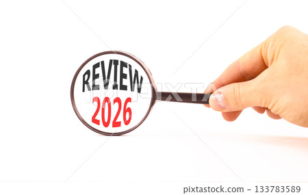 Review 2026 symbol. Concept words Review 2026 on beautiful white paper. Black magnifying glass. Businessman's hand. Beautiful white paper background. Business and review 2026 concept. Copy space. 133783589