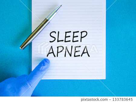 Sleep apnea symbol. Concept words Sleep apnea on beautiful white note. Doctor's hand in blue medical glove. Black pen. Beautiful blue background. Medical healthy lifestyle sleep apnea concept. 133783645
