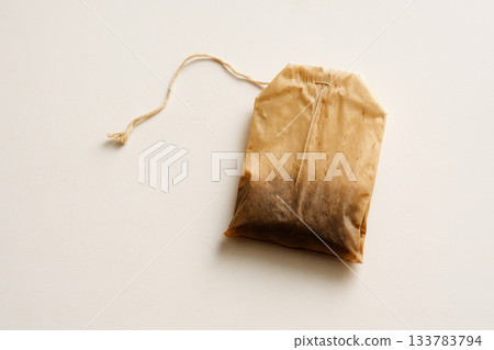 Wet used tea bag on a light background. Space for text. 133783794