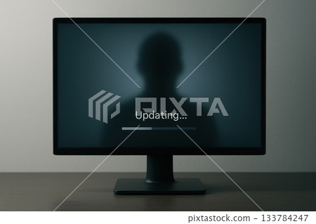 A computer monitor with the inscription Updating and a silhouette of a person. 133784247
