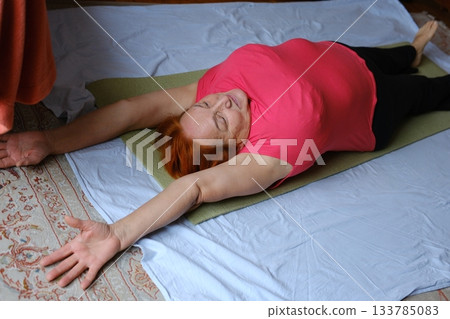 Yoga stretching mat Pleasant 65-Year-Old Woman Does Exercises At Home On A Yoga Mat Yoga stretching mat Pleasant 65-Year-Old Woman Does Exercises At Home On A Yoga Mat 133785083