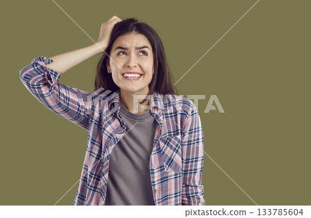 Portrait of funny confused expression young woman who made mistake and thinks how to solve problem. 133785604