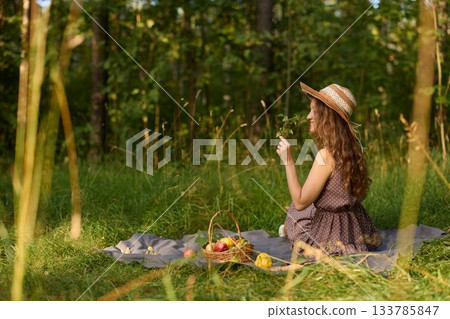 Young lady recording thoughts amidst serene forest environment 133785847