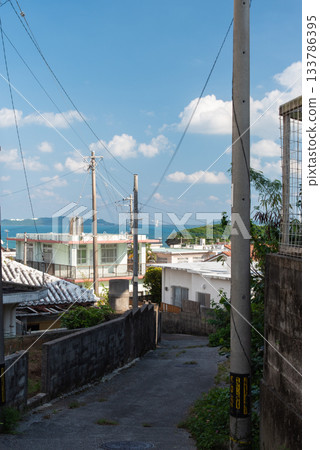 A sunny country backstreet with an emerald green ocean in the distance A sunny country backstreet with an emerald green ocean in the distance 133786395