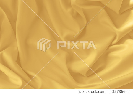 Gold silk fabric background with folds.Copy space. Gold silk fabric background with folds.Copy space. 133786661