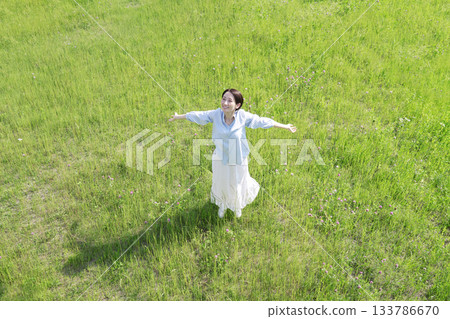 Aerial view of a woman taking a deep breath in the field 133786670