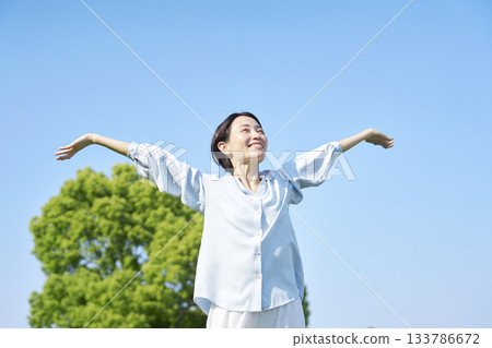 Woman taking a deep breath outdoors Woman taking a deep breath outdoors 133786672