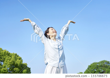 Woman taking a deep breath outdoors Woman taking a deep breath outdoors 133786673
