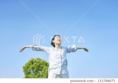 Woman taking a deep breath outdoors 133786675