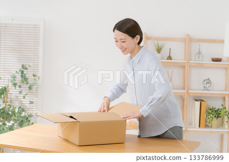 Woman packing clothes into boxes 133786999