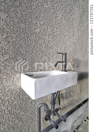 A compact hand washing basin in a garage parking space A compact hand washing basin in a garage parking space 133787261