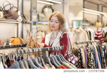 European woman choosing a warm sweater in a shopping mall 133787346