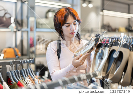 Young woman chooses ballet flats in store Young woman chooses ballet flats in store 133787349