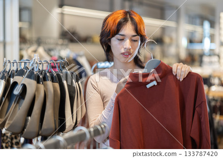 Young Asian woman choosing a wool sweater in a store 133787420
