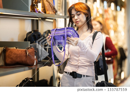 Young woman chooses handbag in accessories boutique 133787559
