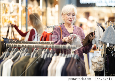 Mature woman choosing high quality hats in the store 133787615