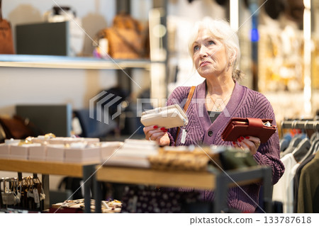 Senior woman at trading floor pick out and buying wallet. 133787618