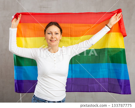 Happy smiling woman proudly displaying rainbow flag Happy smiling woman proudly displaying rainbow flag 133787775
