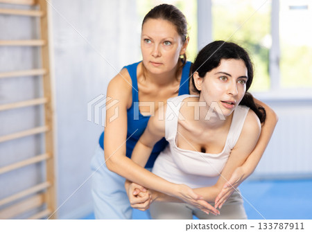 Two women training self-defense techniques in studio 133787911