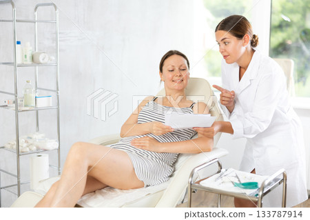 Young woman doctor showing contract to patient 133787914