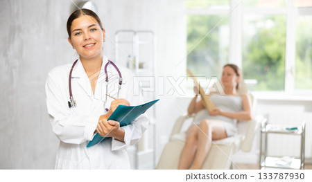 Young female doctor making notes in medical room Young female doctor making notes in medical room 133787930