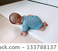 Baby about to fall off baby mat 133788137