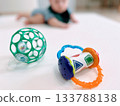 Crawling baby playing with toys on a baby mat 133788138