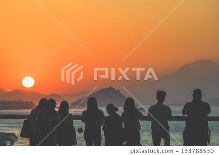 Nov 16 2025 Silhouetted Group At Sunset On Balcony Overlooking City Skyline 133788530