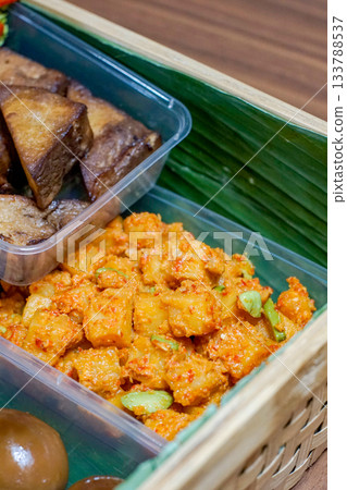 Indonesian Kentang Balado Spicy Potato Dish with Chili Paste and Petai Beans in Traditional Woven Catering Box Indonesian Kentang Balado Spicy Potato Dish with Chili Paste and Petai Beans in Traditional Woven Catering Box 133788537