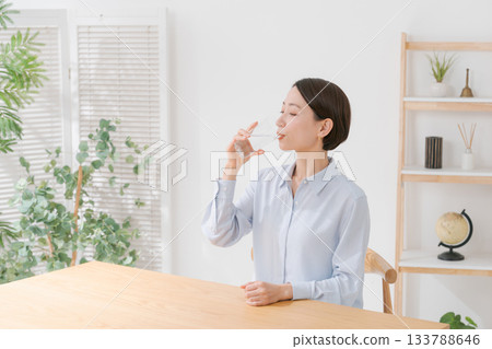 A woman in her 40s drinking water A woman in her 40s drinking water 133788646
