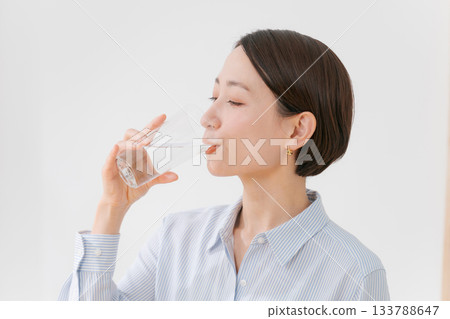 一位四十多歲的婦女正在喝水 一位四十多歲的婦女正在喝水 133788647