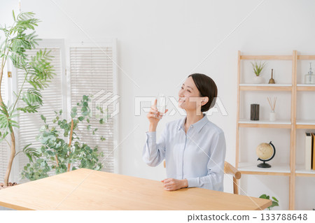 一位四十多歲的婦女正在喝水 一位四十多歲的婦女正在喝水 133788648