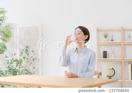 一位四十多歲的婦女正在喝水 133788649