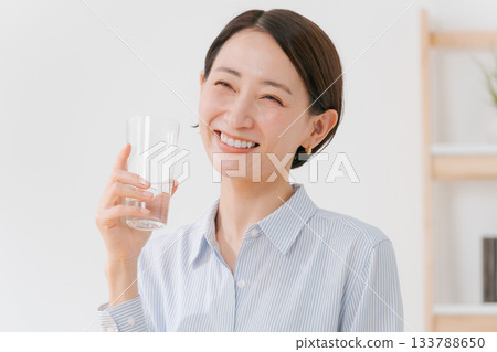 一位四十多歲的婦女正在喝水 133788650