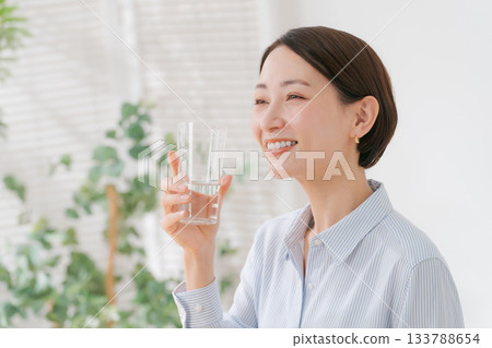 一位四十多歲的婦女正在喝水 133788654