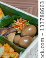 Telur Bacem, Tahu Bacem and Kentang Balado in Banana Leaf Cups inside Woven Bamboo Hamper, Close-up of Authentic Indonesian Cuisine with Glossy Eggs, Braised Tofu and Spicy Potatoes 133788663