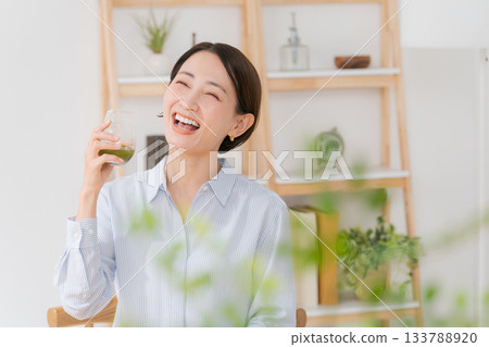 A woman drinking green juice 133788920