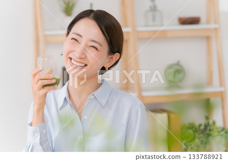 A woman drinking green juice A woman drinking green juice 133788921