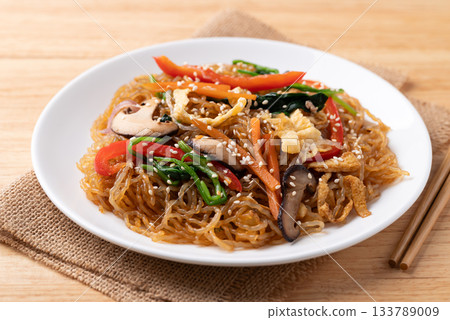 Japchae, Korean stir fried glass noodles with vegetables, pork, soy sauce and sesame oil Japchae, Korean stir fried glass noodles with vegetables, pork, soy sauce and sesame oil 133789009