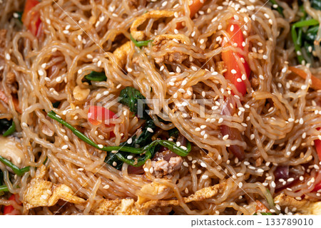 Japchae, Korean stir fried glass noodles with vegetables, pork, soy sauce and sesame oil and seed Japchae, Korean stir fried glass noodles with vegetables, pork, soy sauce and sesame oil and seed 133789010