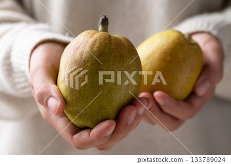 Fresh pear holding by woman hand 133789024
