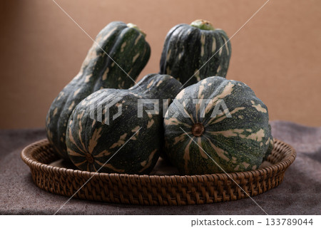 Green butternut squash pumpkin in basket on brown background 133789044