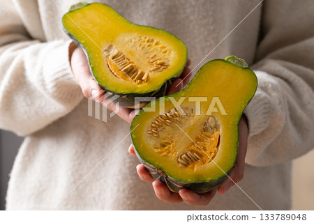 Half green butternut squash pumpkin holding by woman hand 133789048