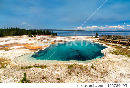 Deep blue Abyss Pool sits near shore of Yellowstone Lake in West Thumb Geyser Basin of Yellowstone National Park, Wyoming. Hot spring features vibrant turquoise water and mineral rim on sunny day 133789495