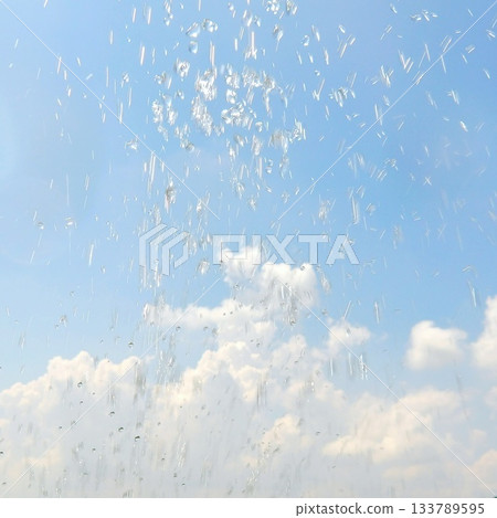 Water splashes flying up against the background of blue sky and white clouds_Refreshing water splashes Water splashes flying up against the background of blue sky and white clouds_Refreshing water splashes 133789595