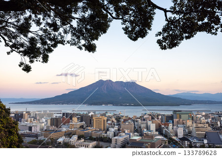 Kagoshima city and Sakurajima in the background seen from the Shiroyama Park Observatory during the magic hour Kagoshima city and Sakurajima in the background seen from the Shiroyama Park Observatory during the magic hour 133789628